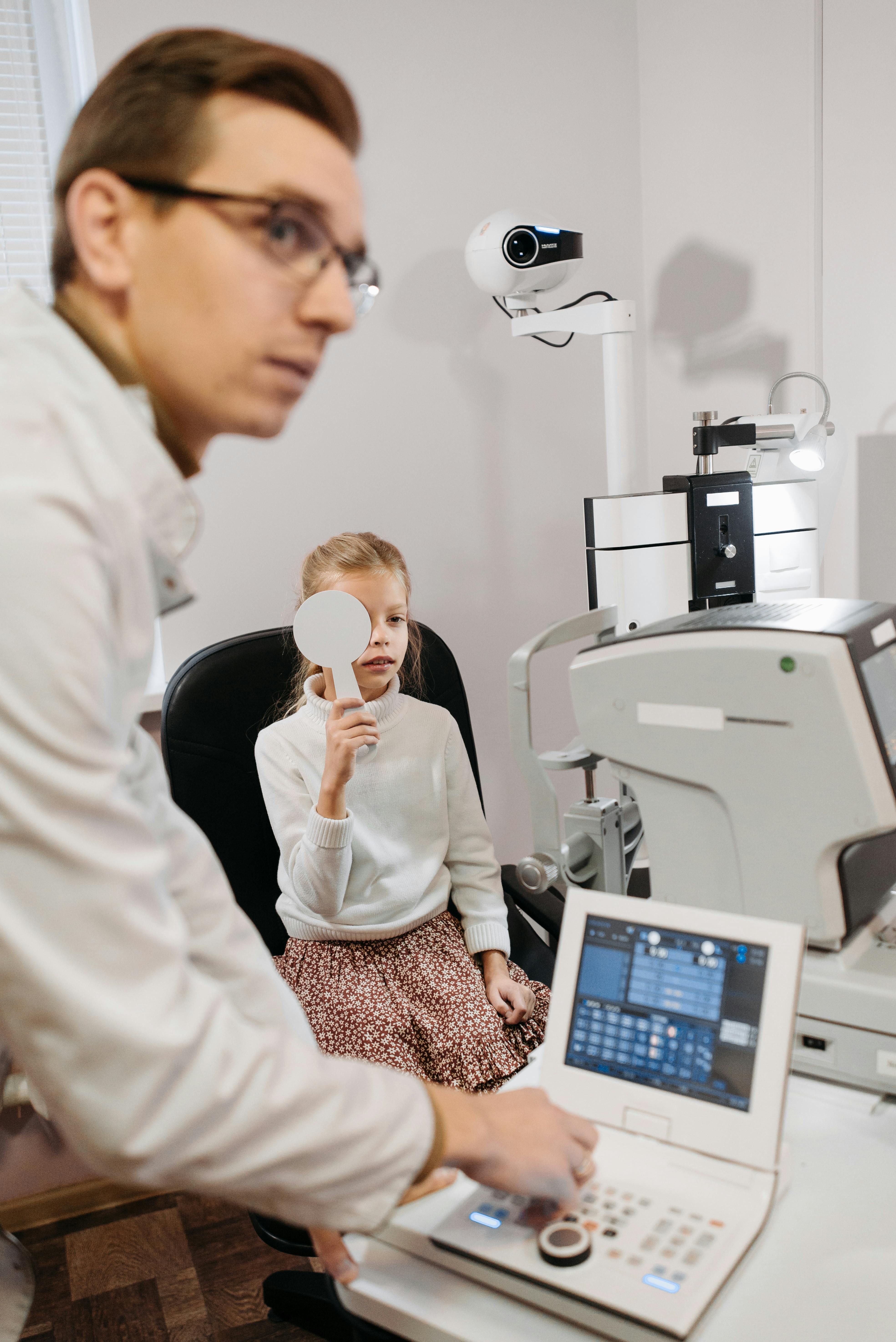 Doctor performing amblyopia eye exam on a child